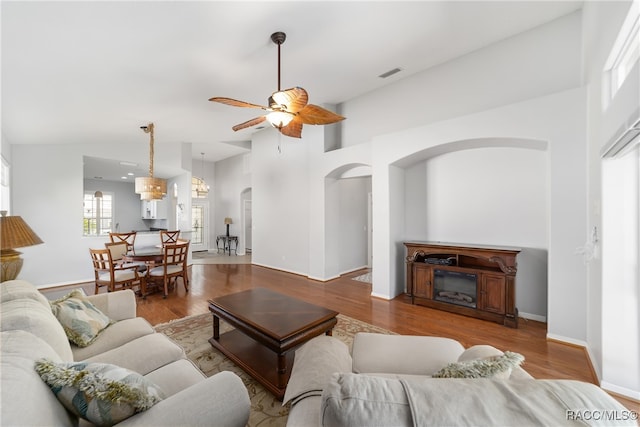 living room with ceiling fan, hardwood / wood-style floors, and high vaulted ceiling