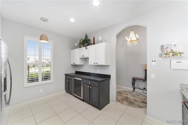 kitchen with stainless steel fridge, light tile patterned flooring, white cabinetry, and beverage cooler