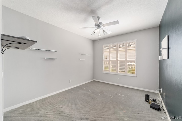 carpeted spare room with a textured ceiling and ceiling fan