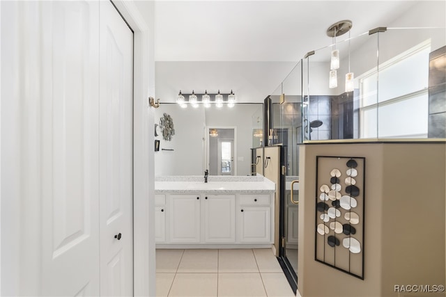 bathroom with tile patterned floors, vanity, and a shower with door