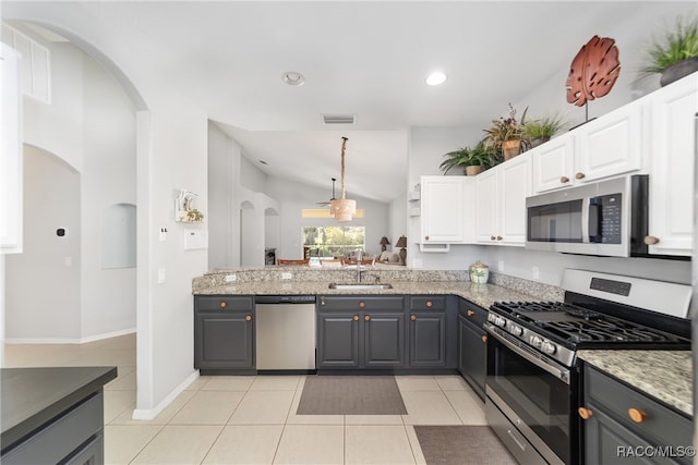 kitchen featuring white cabinetry, stainless steel appliances, lofted ceiling, gray cabinets, and light tile patterned floors