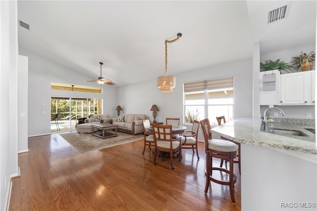 dining room featuring hardwood / wood-style flooring, ceiling fan, lofted ceiling, and sink