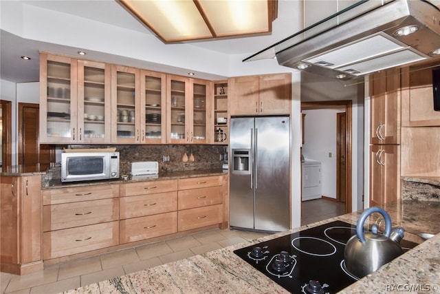 kitchen with stainless steel fridge, black electric stovetop, tasteful backsplash, dark stone counters, and light tile patterned flooring