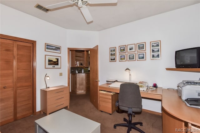 office with dark colored carpet and ceiling fan