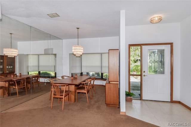 carpeted dining space featuring a textured ceiling and an inviting chandelier