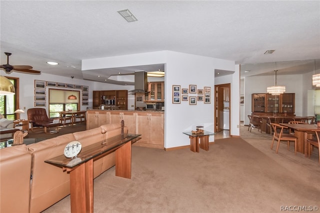 carpeted living room with a textured ceiling and ceiling fan with notable chandelier