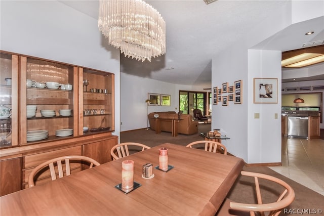 dining space with light tile patterned flooring, a chandelier, and lofted ceiling