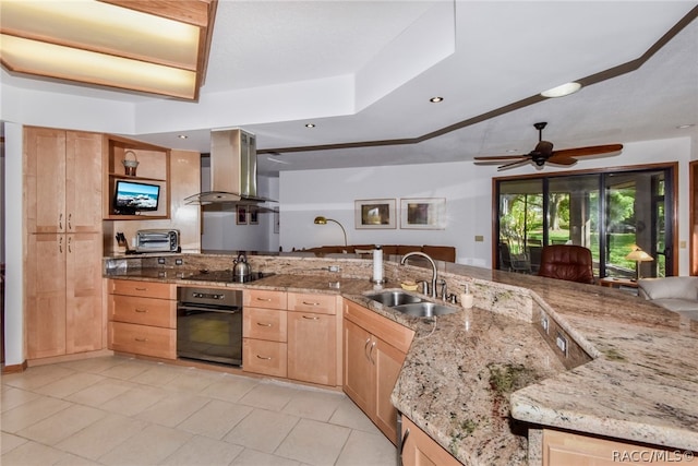 kitchen with light stone countertops, wall chimney exhaust hood, sink, black appliances, and light brown cabinets