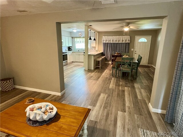 dining area with wood-type flooring and ceiling fan