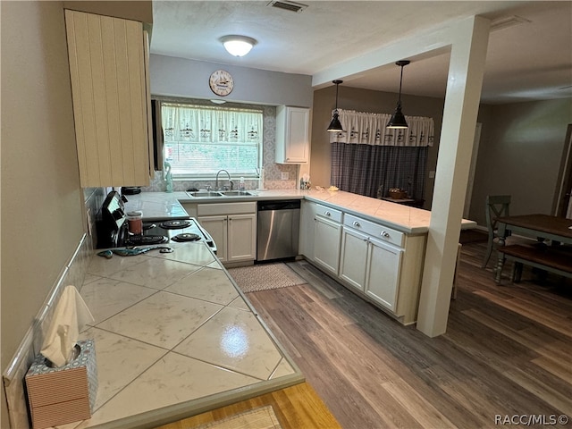 kitchen featuring white cabinetry, dishwasher, sink, hardwood / wood-style floors, and decorative light fixtures