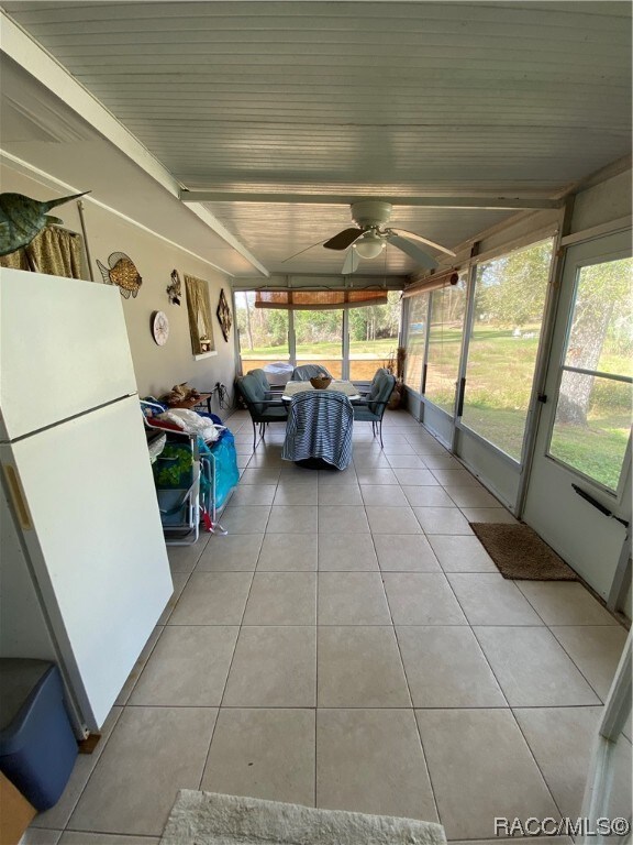 unfurnished sunroom featuring ceiling fan