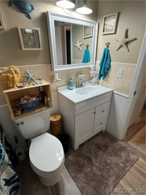 bathroom featuring vanity, hardwood / wood-style flooring, and toilet