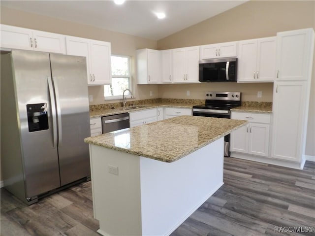 kitchen featuring white cabinets, a kitchen island, lofted ceiling, and stainless steel appliances