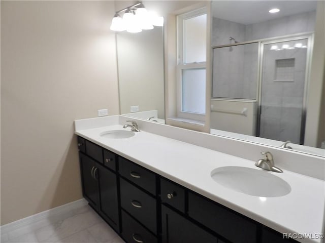 bathroom with vanity and a shower with door