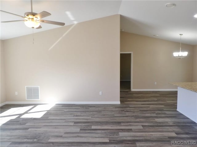 unfurnished living room featuring dark hardwood / wood-style floors, ceiling fan with notable chandelier, and vaulted ceiling