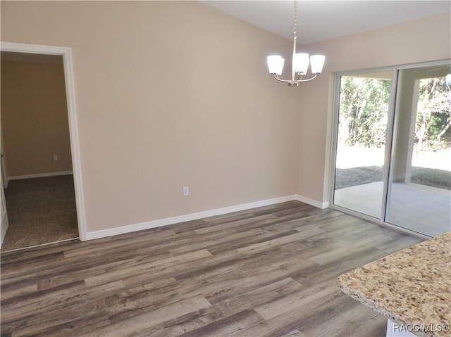 unfurnished dining area with dark hardwood / wood-style floors and a chandelier