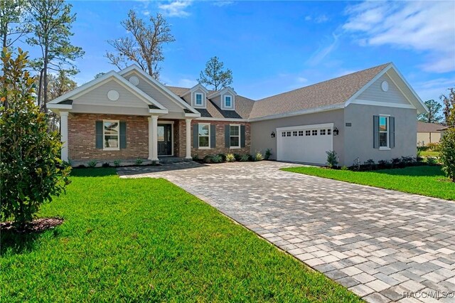 view of front of property featuring a garage, decorative driveway, brick siding, and a front lawn