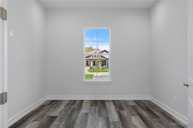 empty room featuring dark wood-style flooring and baseboards