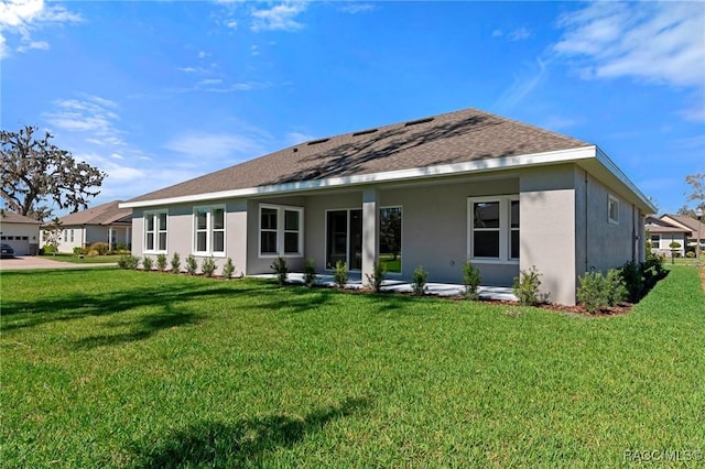 back of property featuring a shingled roof, a patio area, a yard, and stucco siding