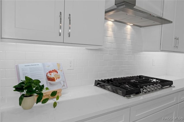 kitchen with light countertops, exhaust hood, white cabinetry, and stainless steel gas stovetop