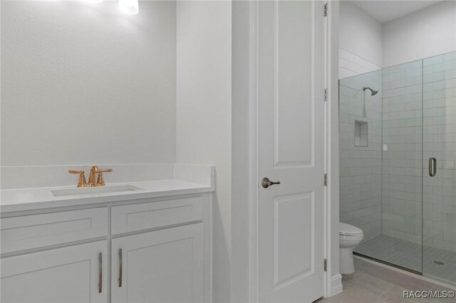 bathroom with vanity, a stall shower, tile patterned flooring, and toilet