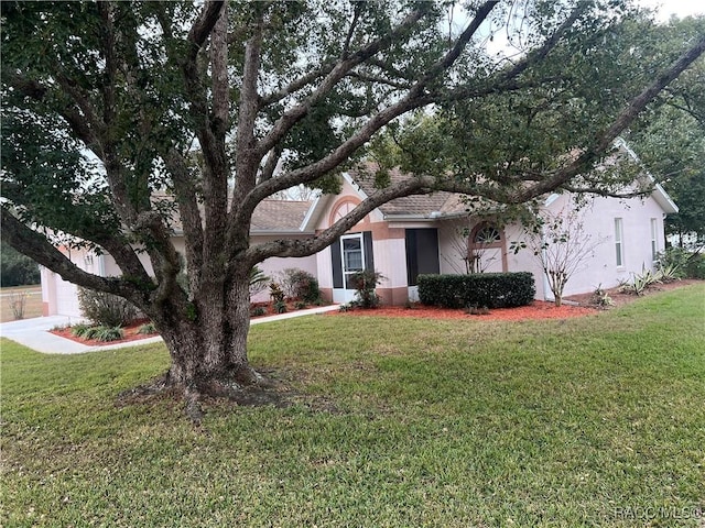 view of front of home with a garage and a front lawn