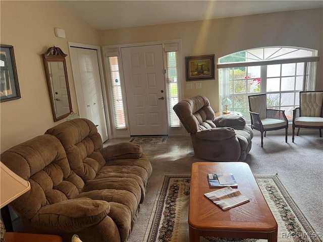 living room with dark colored carpet, vaulted ceiling, and plenty of natural light