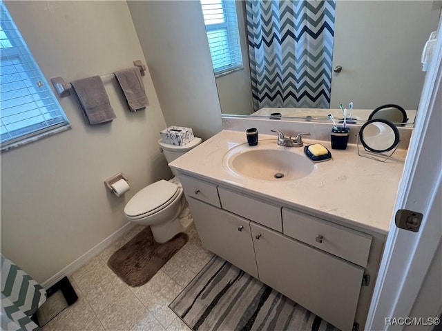 bathroom featuring a wealth of natural light, vanity, and toilet