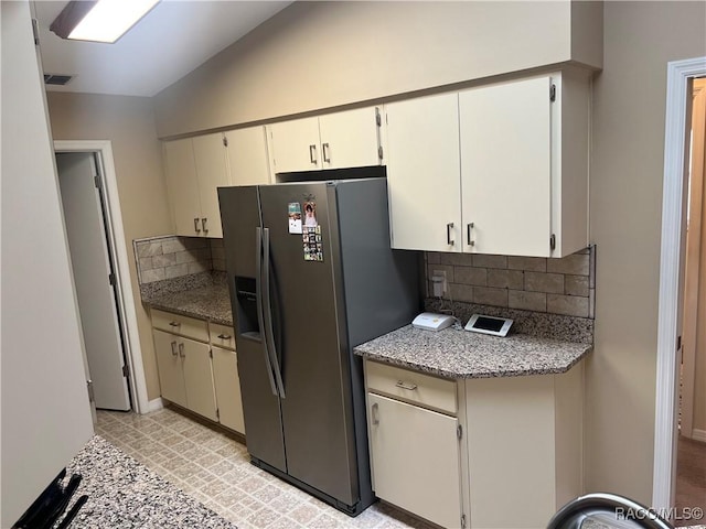 kitchen with vaulted ceiling, white cabinets, backsplash, and stainless steel fridge with ice dispenser