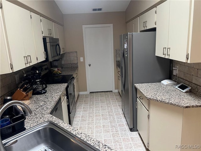 kitchen with stainless steel appliances, white cabinetry, and backsplash