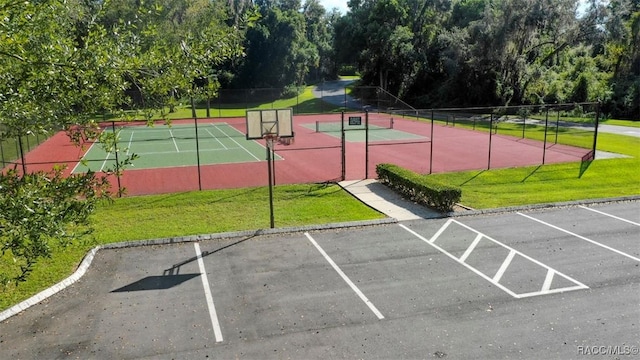 view of sport court featuring basketball court and a lawn