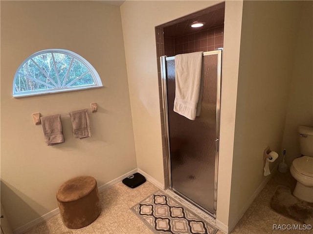 bathroom with toilet and a shower with shower door