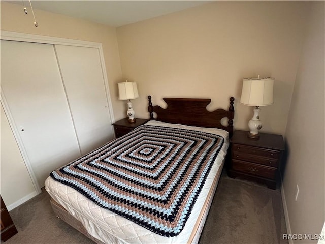 bedroom with dark carpet and a closet