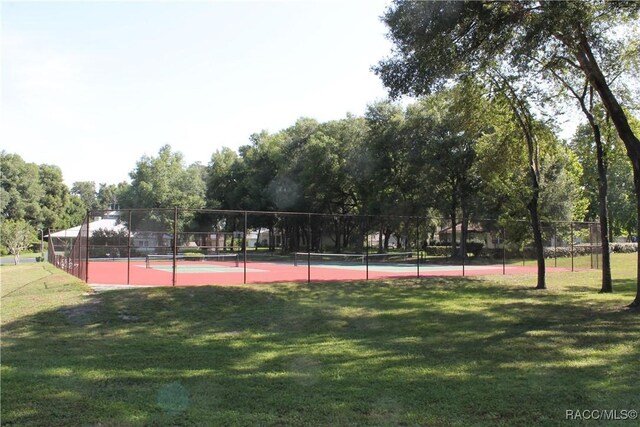 view of sport court featuring a lawn