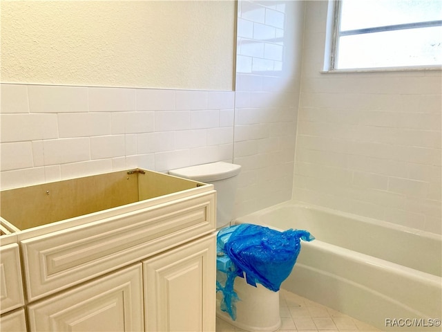 bathroom featuring tile patterned flooring and tile walls