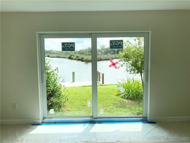 doorway to outside featuring a water view and a healthy amount of sunlight