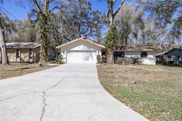 ranch-style house featuring a garage, concrete driveway, and a front yard