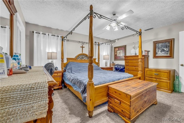 bedroom with visible vents, carpet, and a textured ceiling