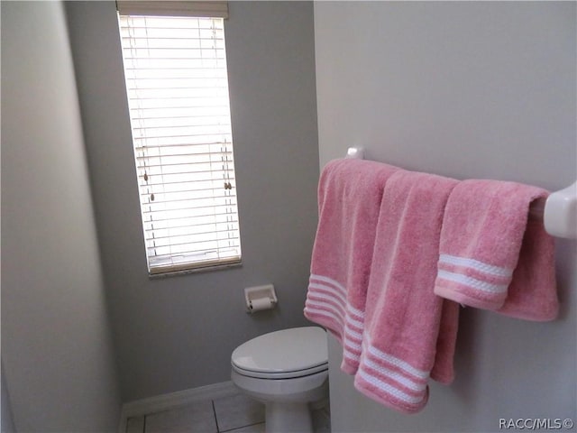 bathroom featuring tile patterned floors, toilet, and a wealth of natural light