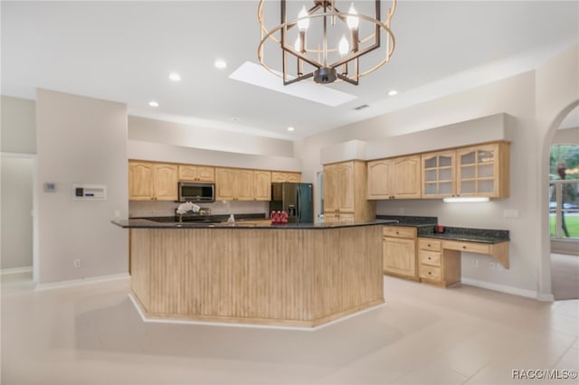 kitchen featuring light brown cabinetry, hanging light fixtures, stainless steel appliances, and a kitchen island