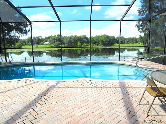 view of swimming pool featuring a lanai, a patio area, and a water view