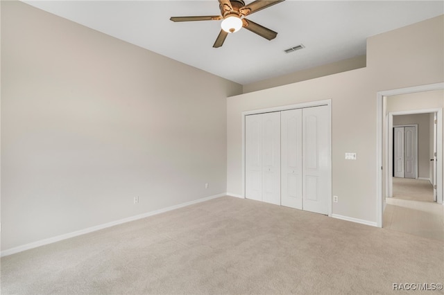 unfurnished bedroom featuring light carpet, a closet, and ceiling fan