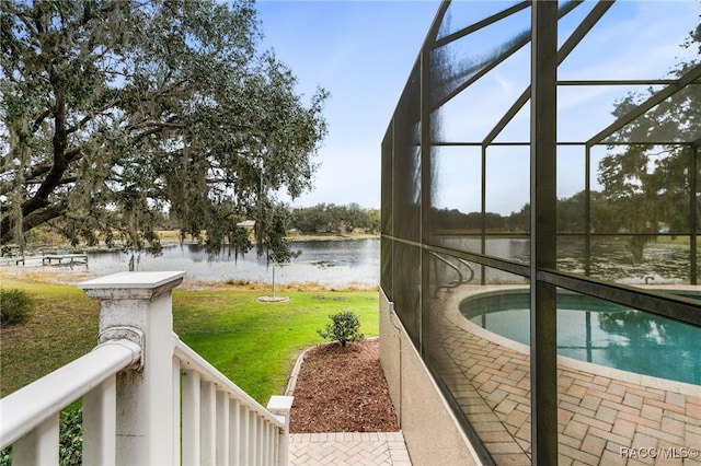 exterior space featuring a water view, a yard, and glass enclosure