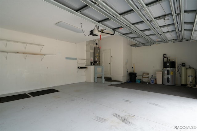 garage featuring hybrid water heater, gas water heater, and a garage door opener