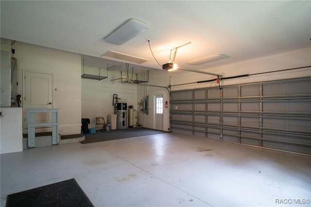 garage with a garage door opener, hybrid water heater, and electric panel