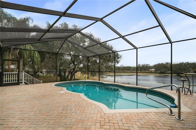 view of swimming pool with a patio area, a water view, and glass enclosure