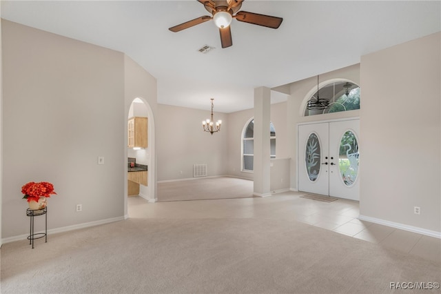 entryway featuring ceiling fan with notable chandelier, light carpet, and french doors