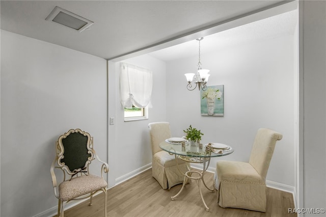 dining room featuring baseboards, an inviting chandelier, and wood finished floors