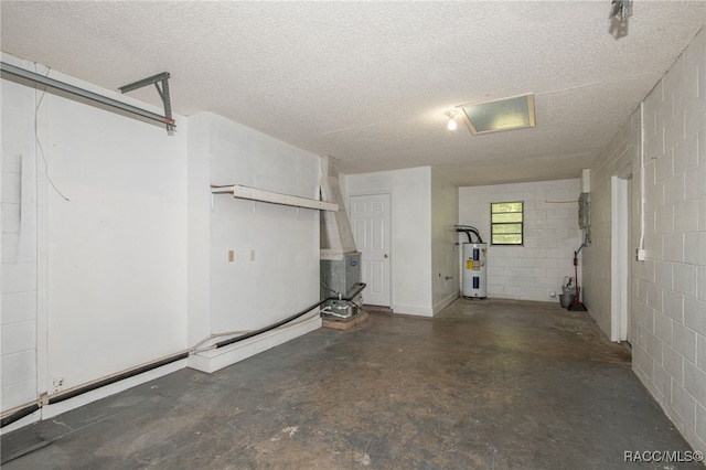 garage featuring electric water heater and concrete block wall