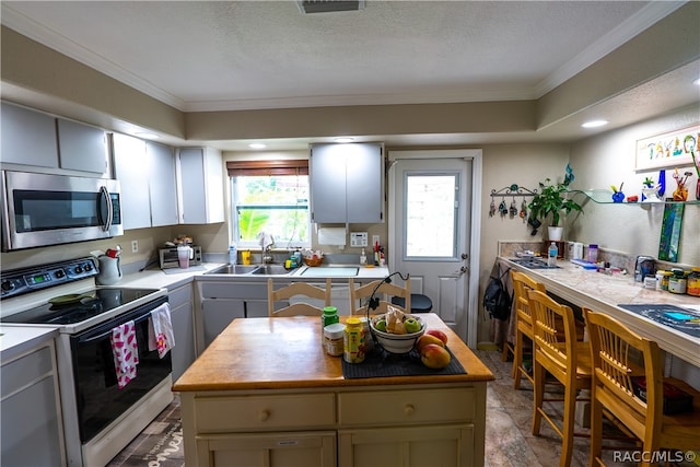 kitchen featuring white electric stove, a kitchen island, and crown molding